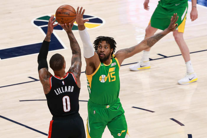 Derrick Favors (15) looks to block Damian Lillard's (0) shot